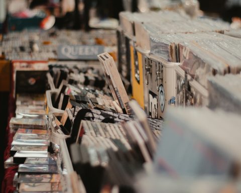 Stapel mit Schallplatten und CDs auf einem Tisch, unordentlich angeordnet.